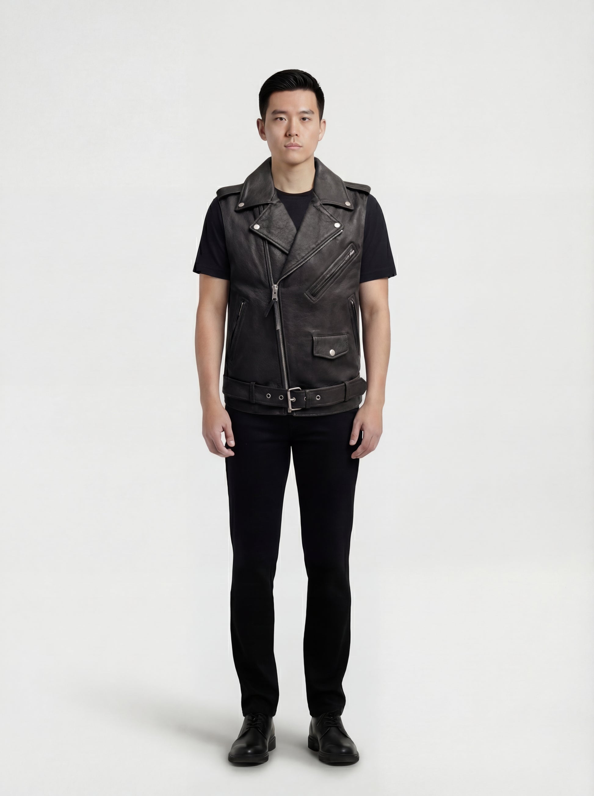 Male model wearing Maverick Ryder leather biker vest, regular fit, styled over a grey hoodie with black distressed denim jeans. Maverick Jacket.