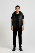 Male model wearing Maverick Reid quilted leather hooded vest, regular fit, styled over a grey hoodie with black cargo trousers. Maverick Jacket.