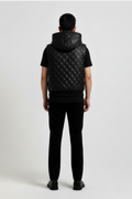 Rear view of male model wearing Maverick Reid quilted leather hooded vest showing broad shoulder fit and hood drape styling. Maverick Jacket.