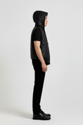 Side profile of Maverick Reid quilted leather hooded vest showing sleeveless armhole structure and sporty hooded silhouette. Maverick Jacket.