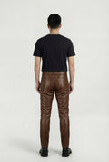 Rear view of male model wearing Maverick Nolan quilted leather pants showing fitted seat silhouette and rear pocket styling. Maverick Jacket.
