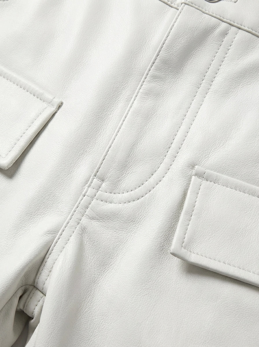 Macro shot of white pebbled leather texture and heavy-duty stitching detail on cargo pants. The Cassian by Maverick Jacket.