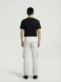 Rear view of male model wearing Maverick Cassian white leather cargo pants showing fitted seat silhouette and rear pocket styling. Maverick Jacket.