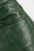 Macro shot of smooth forest green leather texture and coin pocket stitching on pants. Maverick Finnian.