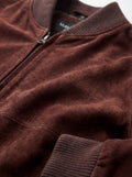 Macro shot of soft brown suede texture and metal zipper hardware on bomber jacket. The Miles by Maverick Jacket.