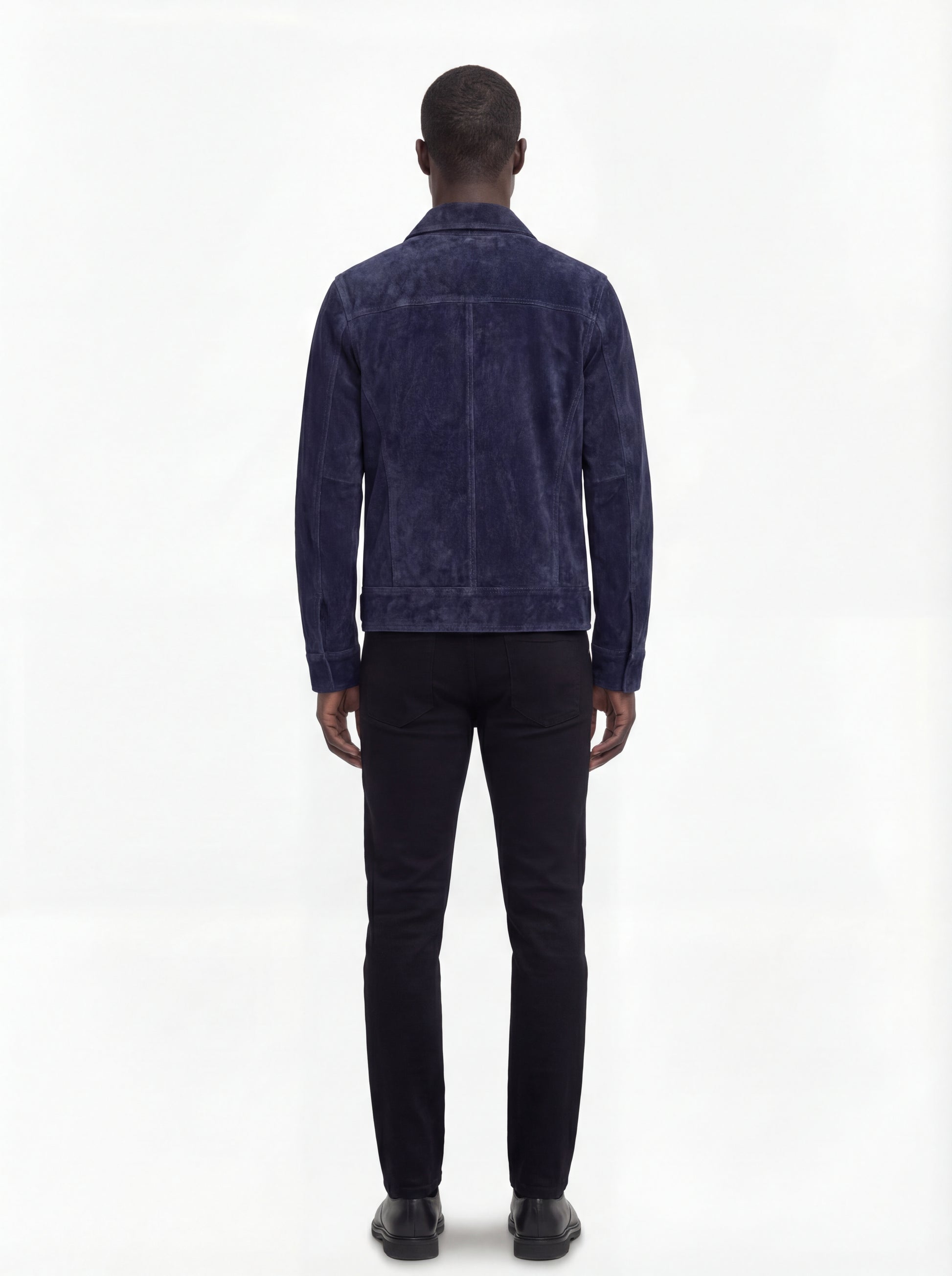 Rear view of male model wearing Maverick August suede trucker jacket showing tailored shoulder fit and clean back paneling. Maverick Jacket.