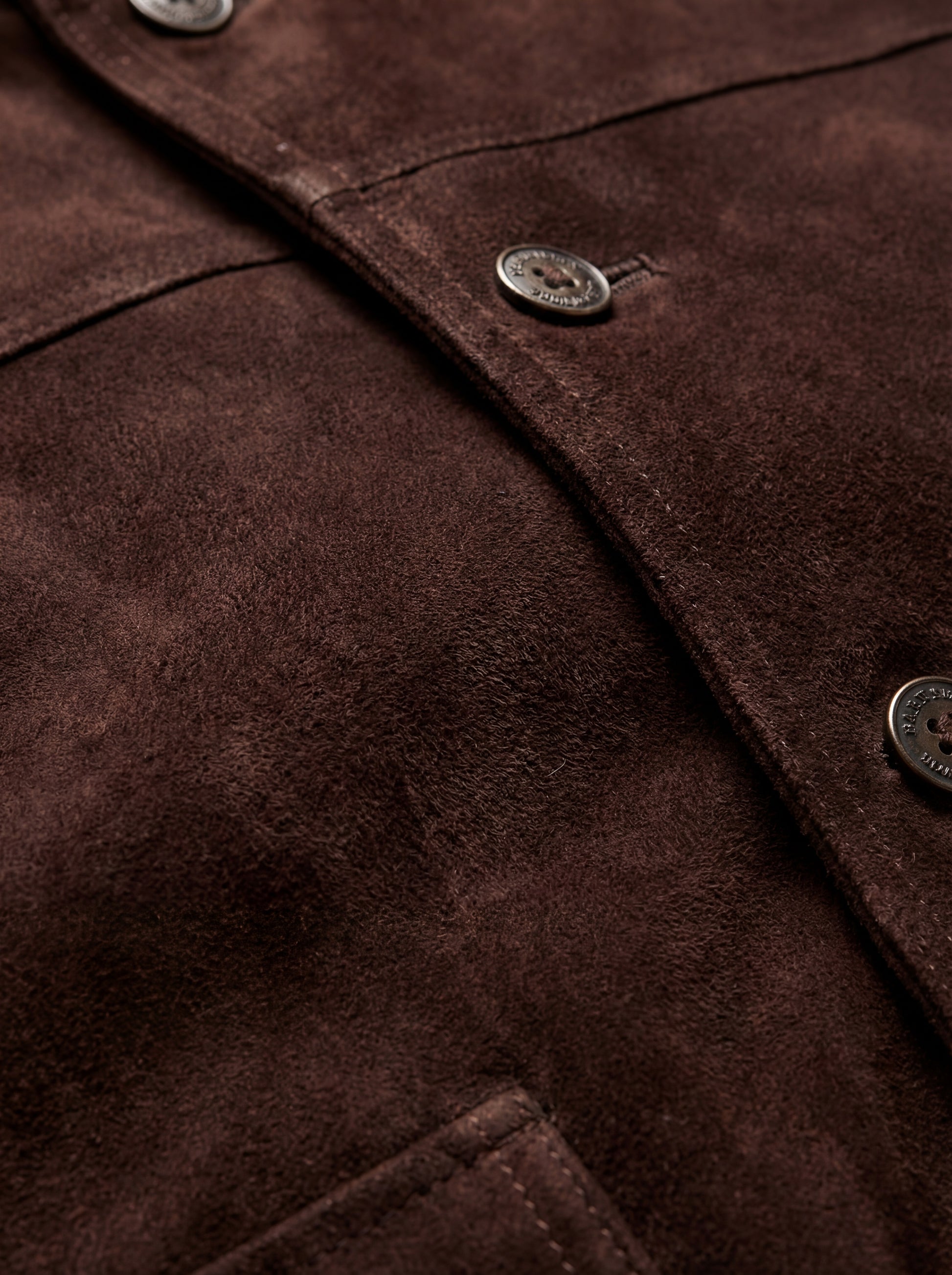 Macro shot of soft brown suede texture and metal zipper hardware on bomber jacket. The Arthur by Maverick Jacket.