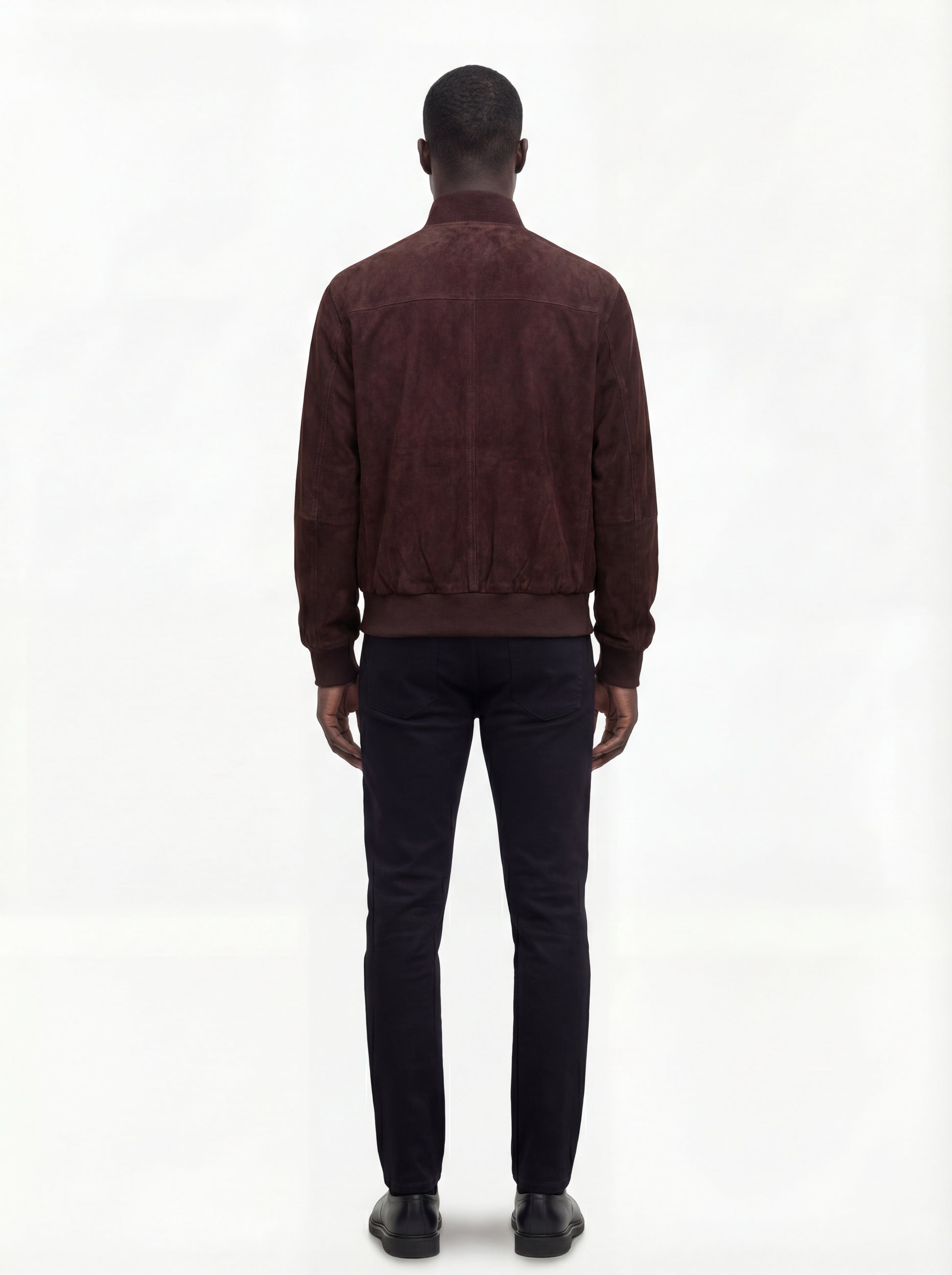 Rear view of male model wearing Maverick Arthur suede bomber jacket showing broad shoulder fit and ribbed waist styling. Maverick Jacket.