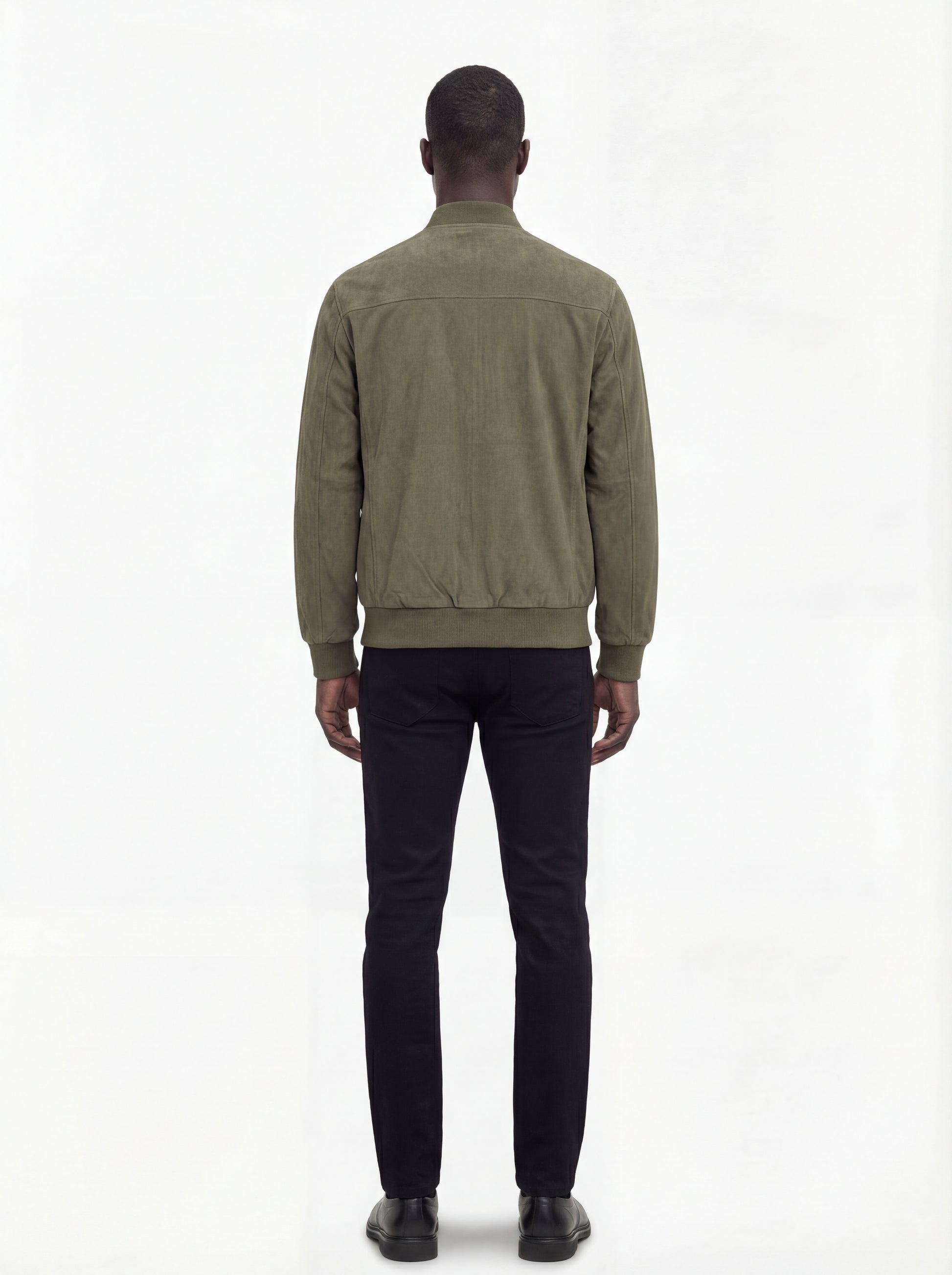 Rear view of male model wearing Maverick Evan suede bomber jacket showing broad shoulder fit and ribbed waist styling. Maverick Jacket.