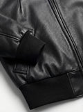 Macro shot of grained black leather texture and ribbed knit cuff detail on bomber jacket. The Isla by Maverick Jacket.