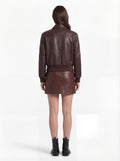Rear view of female model wearing Maverick Isla leather bomber jacket showing structured shoulder fit and elasticated hem styling. Maverick Jacket.