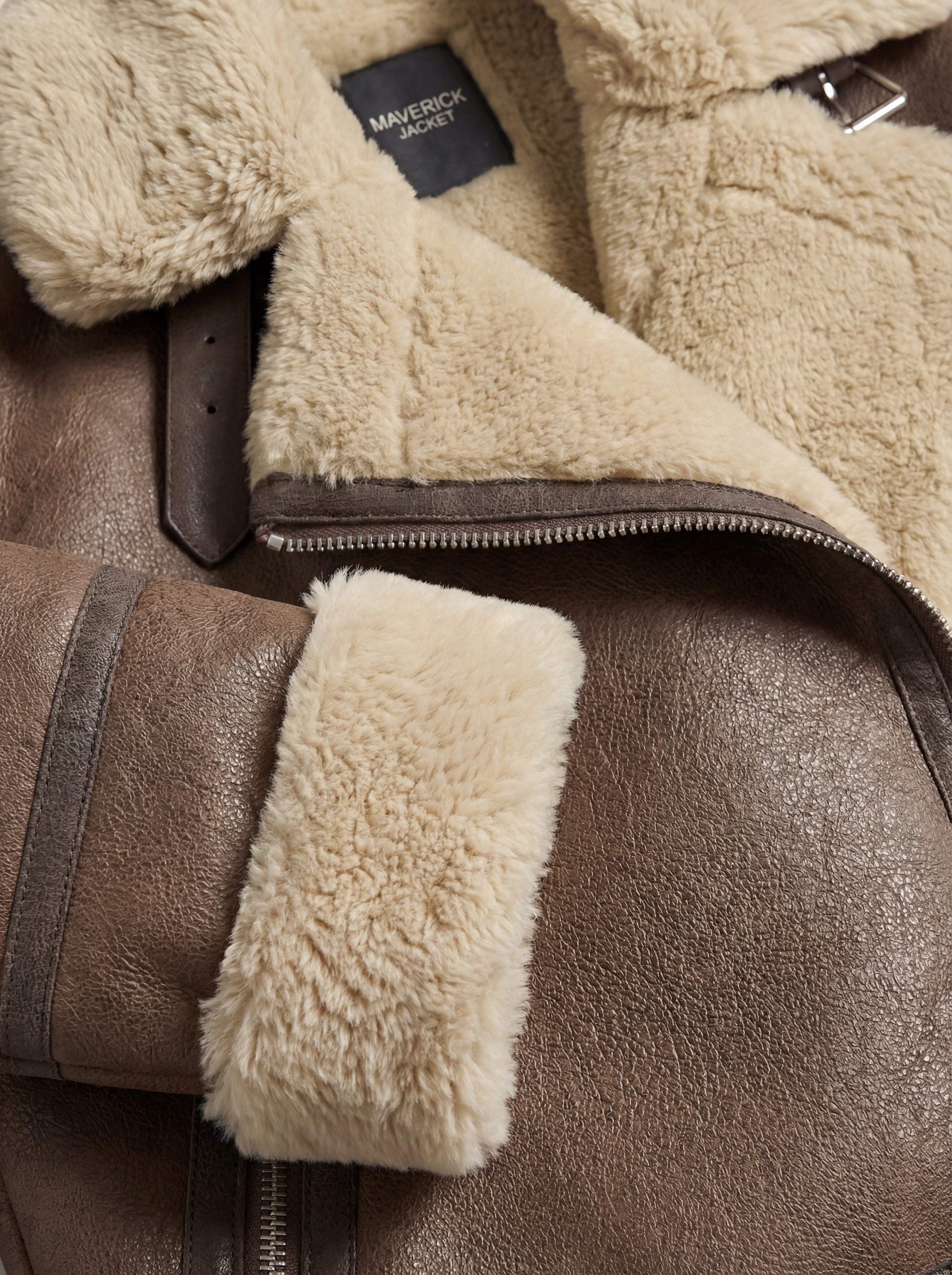 Macro shot of soft cream shearling wool texture and brown leather grain on collar and cuff. The Amelia by Maverick Jacket.