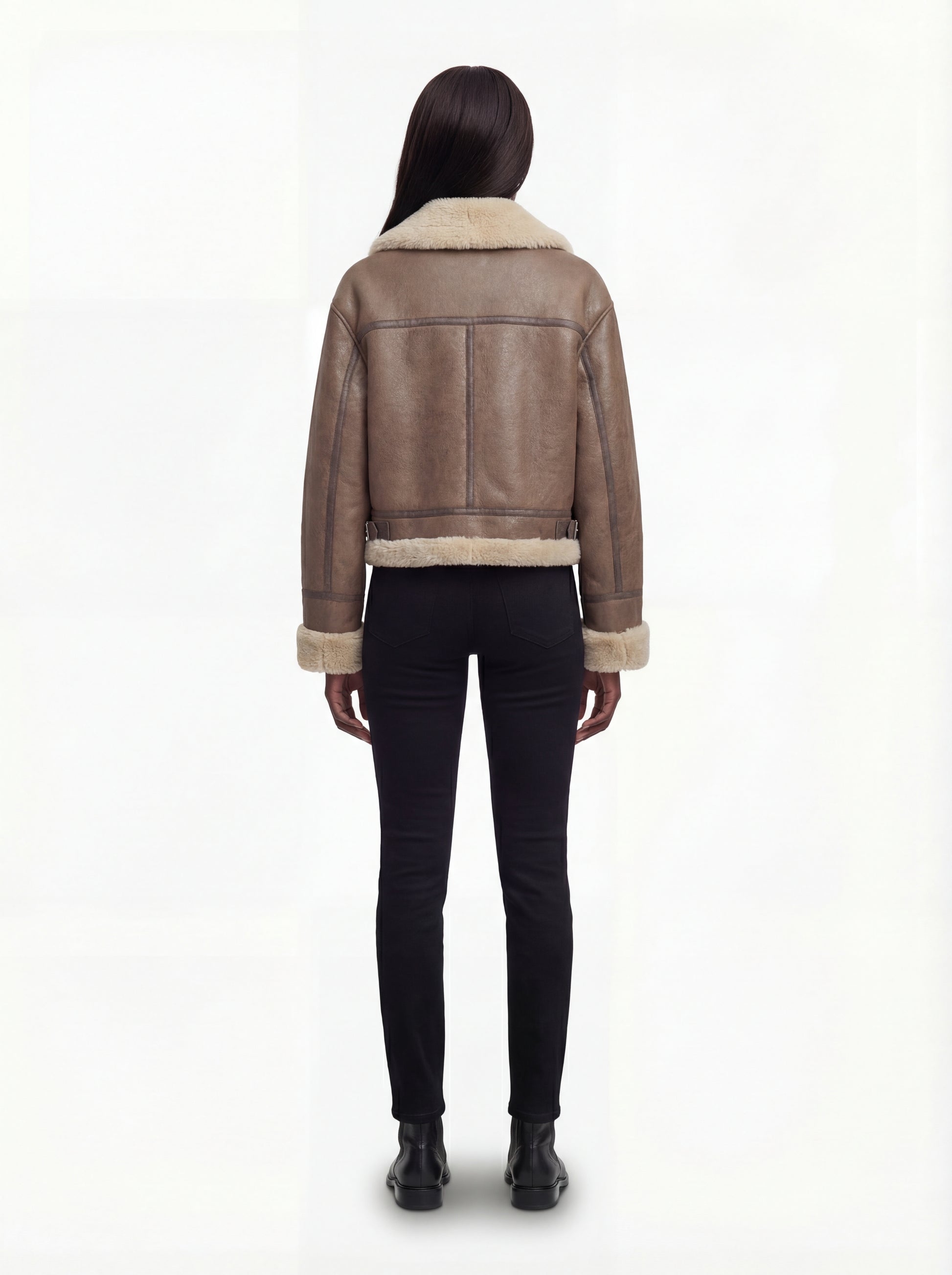 Rear view of female model wearing Maverick Amelia aviator jacket showing structured shoulder fit and fur-lined hem. Maverick Jacket.