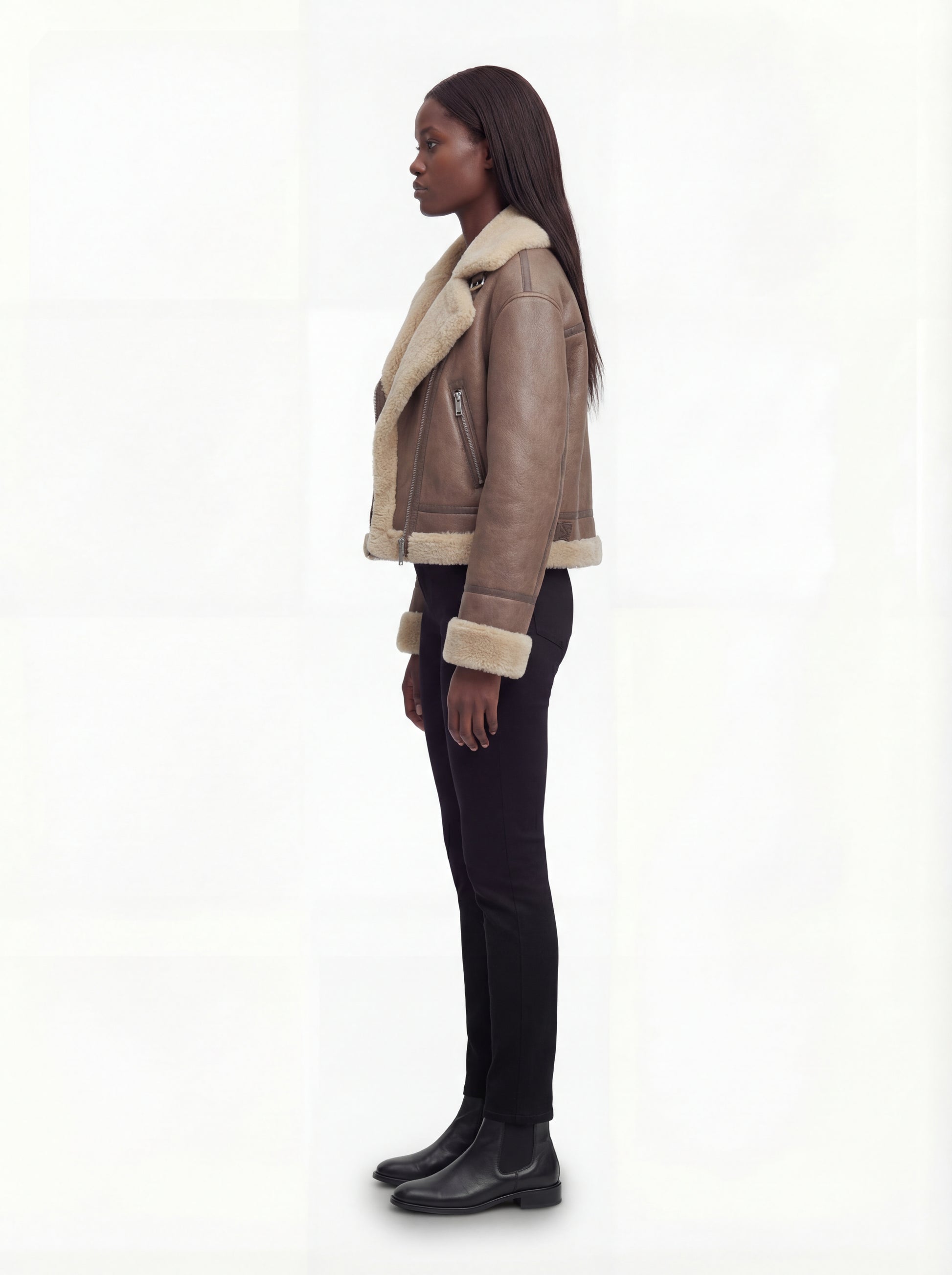 Side profile of Maverick Amelia aviator jacket showing long leather sleeves with fur cuffs and boxy silhouette. Maverick Jacket.