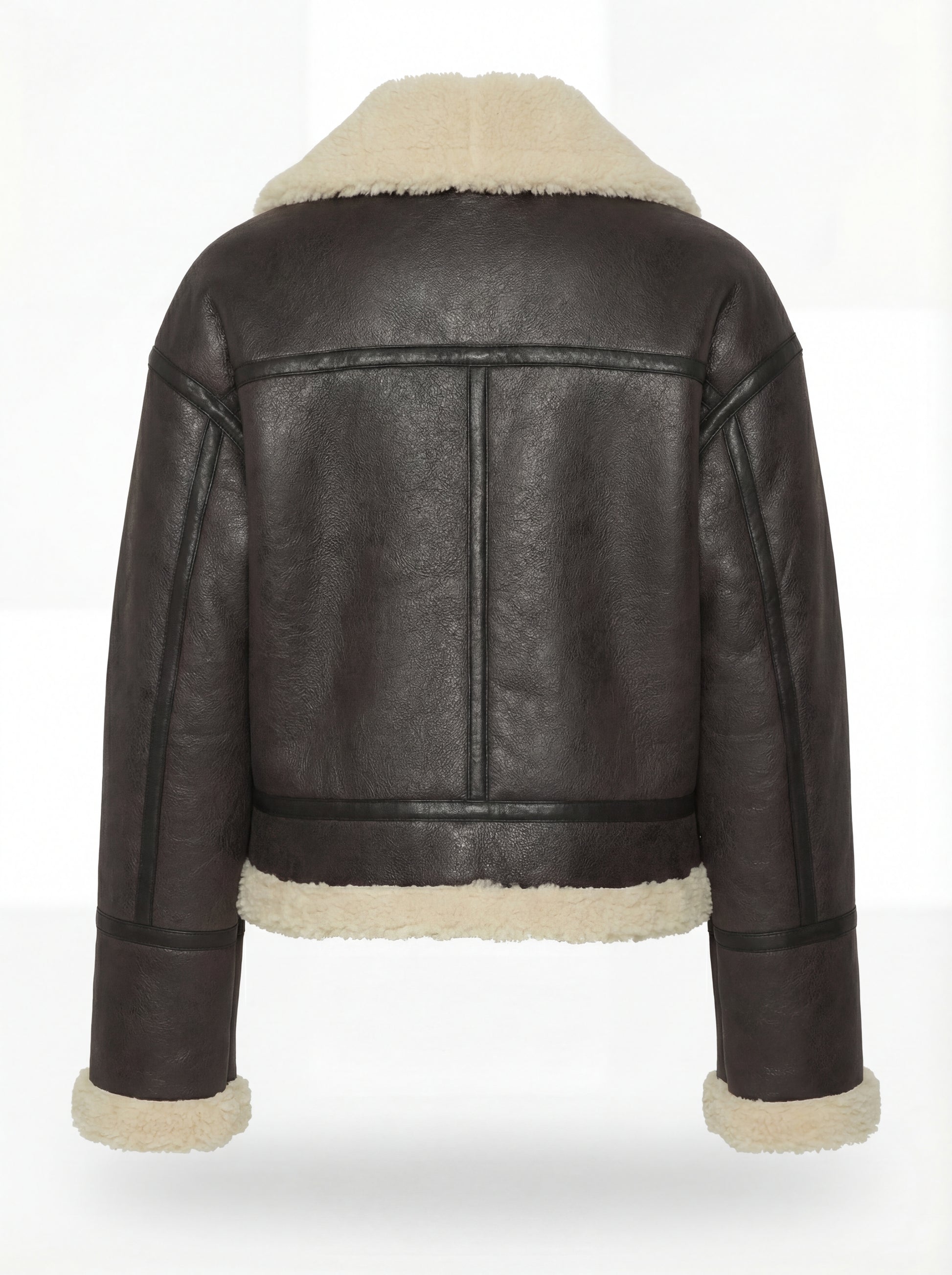 Rear view of black leather aviator jacket showing vertical center seam and cream shearling hem. The Thea by Maverick Jacket.