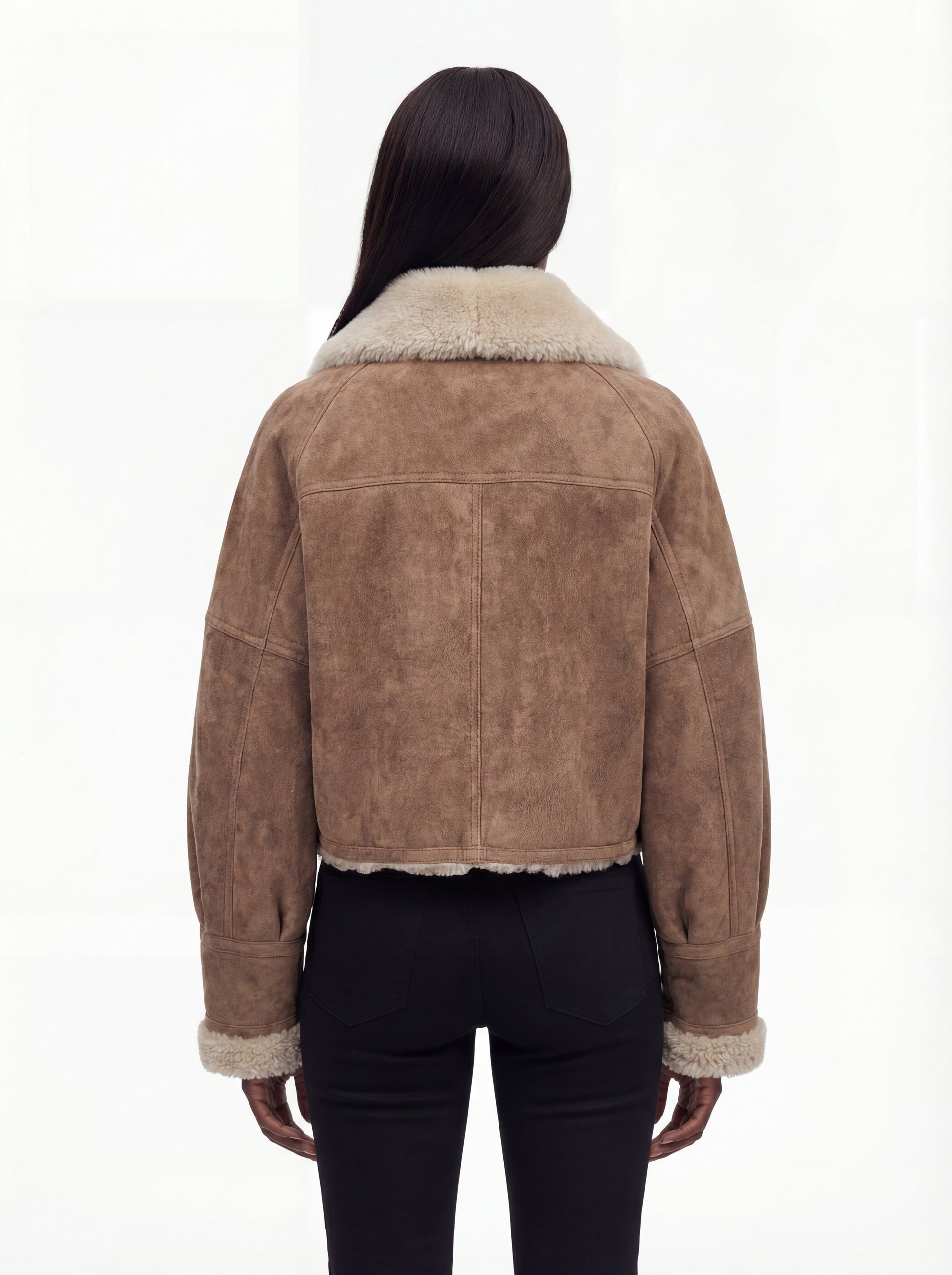 Rear view of female model wearing Maverick Anya shearling aviator jacket showing dropped shoulders and cream shearling hem trim. Maverick Anya.