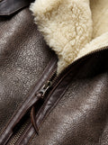Macro shot of distressed brown leather texture and thick cream shearling lapel detail on aviator jacket. Maverick Paige.