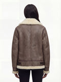 Rear view of female model wearing Maverick Paige shearling aviator jacket showing structured shoulders and shearling-trimmed hem. Maverick Paige.