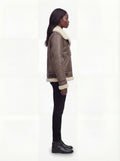 Side profile of Maverick Paige aviator jacket showing shearling cuffs and boxy hip-length silhouette. Maverick Paige.