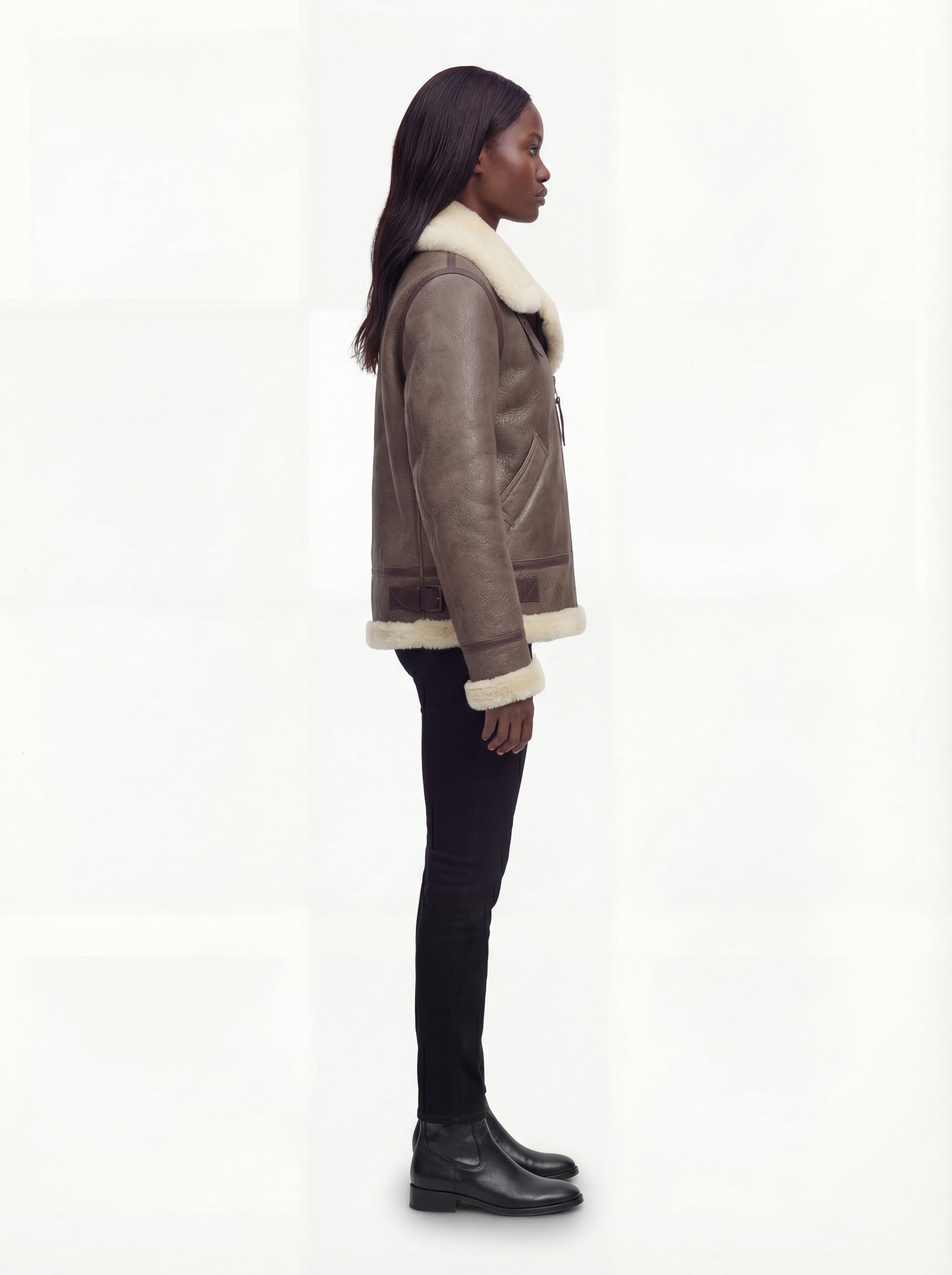 Side profile of Maverick Paige aviator jacket showing shearling cuffs and boxy hip-length silhouette. Maverick Paige.