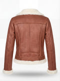 Rear view of tan leather shearling biker jacket showing vertical panel seams and cream shearling hem. Maverick Fallon.