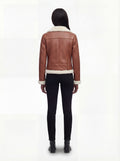 Rear view of female model wearing Maverick Fallon shearling biker jacket showing fitted shoulders and cream fur hem trim. Maverick Fallon.