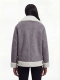 Rear view of female model wearing Maverick Esme shearling aviator jacket showing dropped shoulders and white shearling hem trim. Maverick Esme.