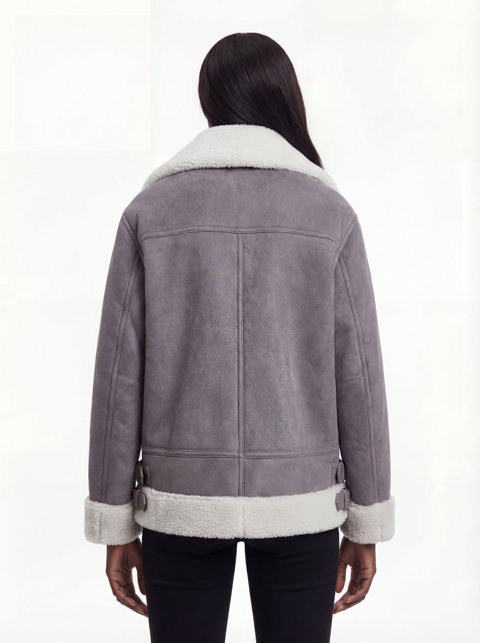 Rear view of female model wearing Maverick Esme shearling aviator jacket showing dropped shoulders and white shearling hem trim. Maverick Esme.