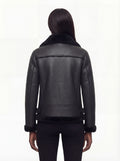Rear view of female model wearing Maverick Nova shearling aviator jacket showing structured shoulders and shearling-trimmed hem. Maverick Nova.