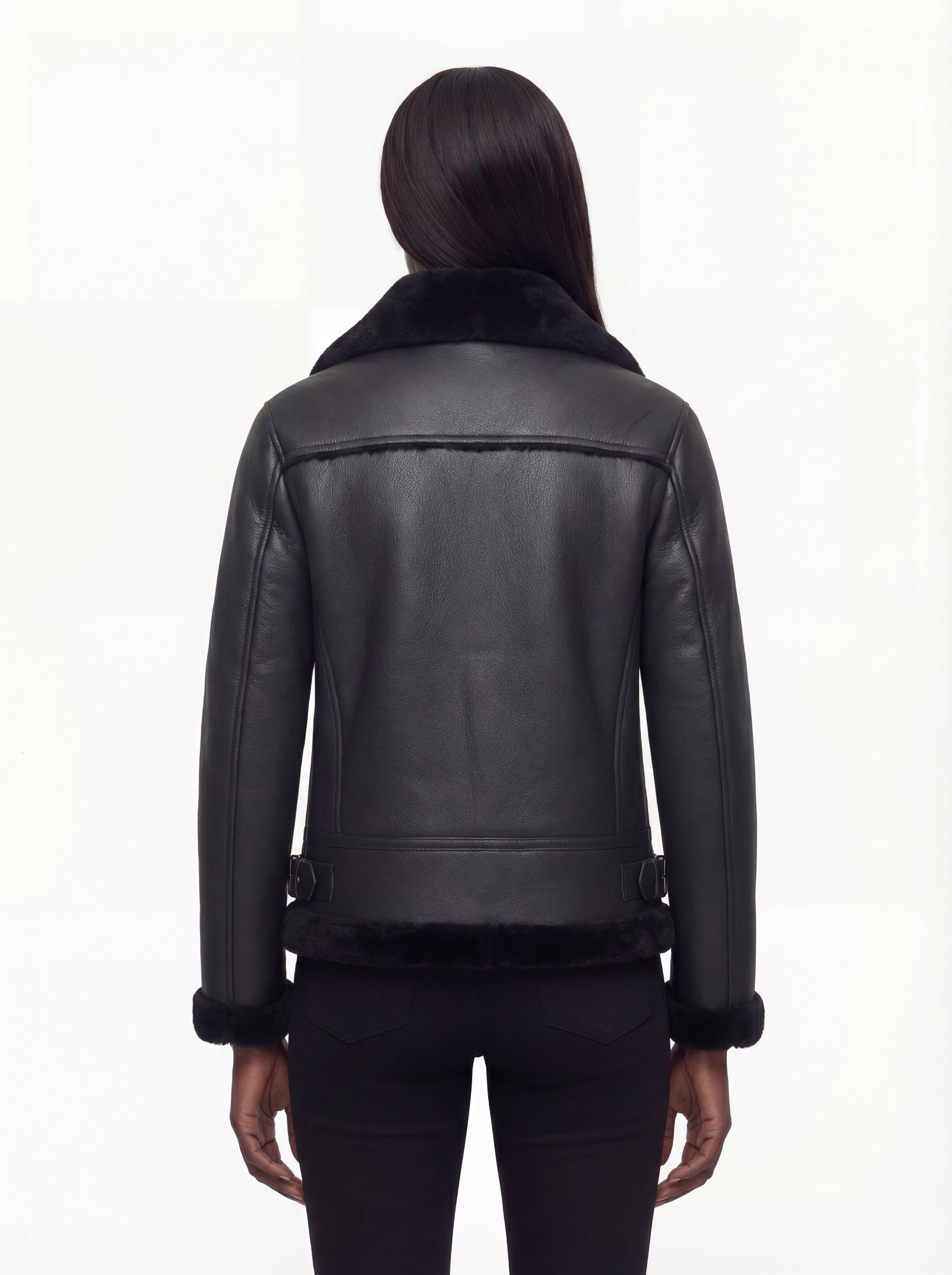 Rear view of female model wearing Maverick Nova shearling aviator jacket showing structured shoulders and shearling-trimmed hem. Maverick Nova.