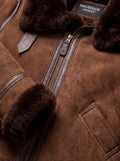 Macro shot of soft brown suede texture and brass zipper with leather puller on aviator jacket. The Eliza by Maverick Jacket.