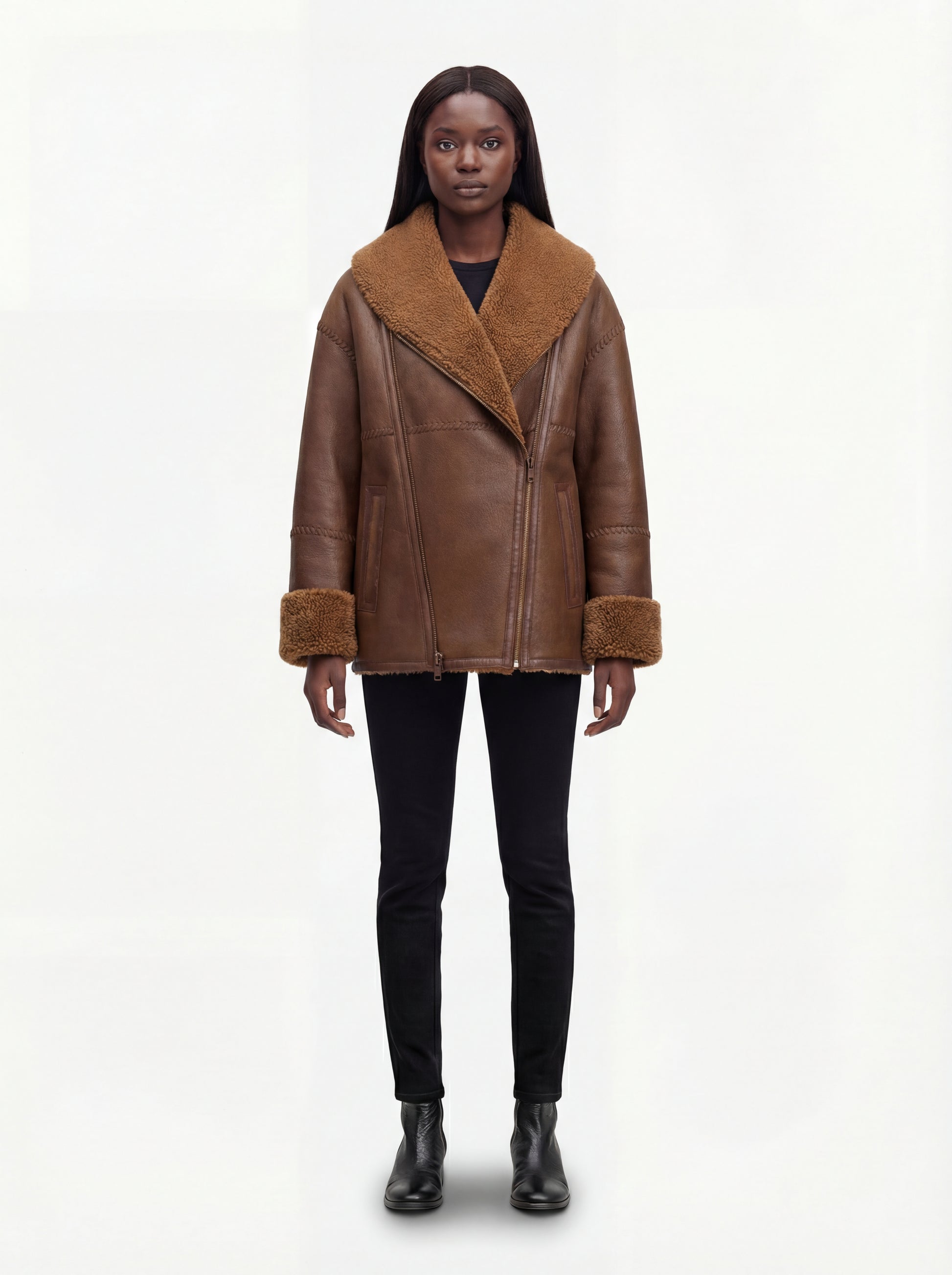 Female model wearing Maverick Greta oversized shearling jacket, relaxed fit, styled with black skinny jeans and black Chelsea boots. Maverick Greta.