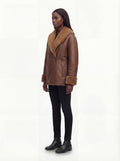 Side profile of Maverick Greta shearling jacket showing shearling cuff detail and boxy oversized silhouette. Maverick Greta.