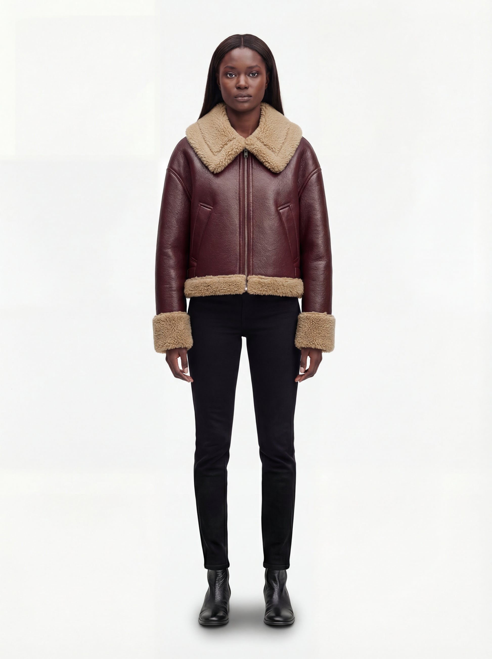 Female model wearing Maverick Faye shearling jacket, boxy fit, styled with black skinny jeans and black leather boots. Maverick Faye.