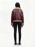 Rear view of female model wearing Maverick Faye shearling jacket showing relaxed shoulder drop and shearling-trimmed hem. Maverick Faye.