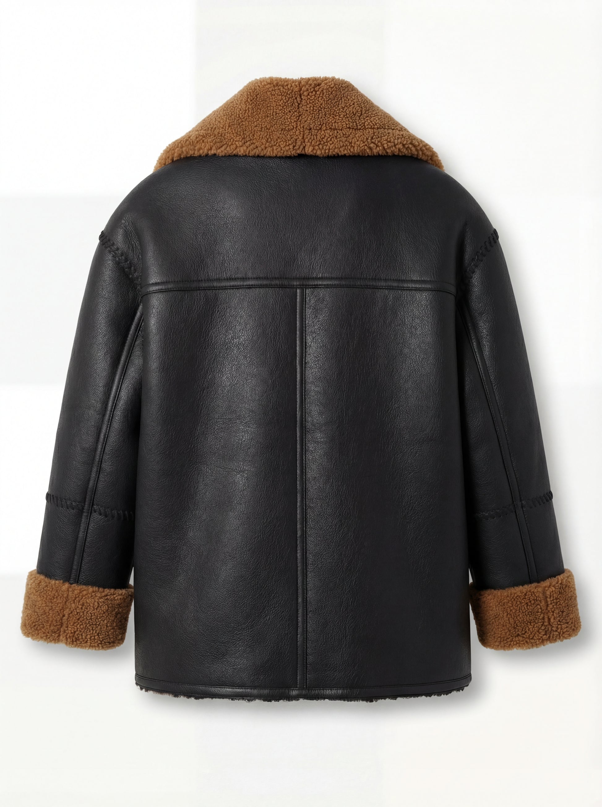 Rear view of black and tan shearling jacket showing vertical center seam and braided sleeve seams. Maverick Noa.