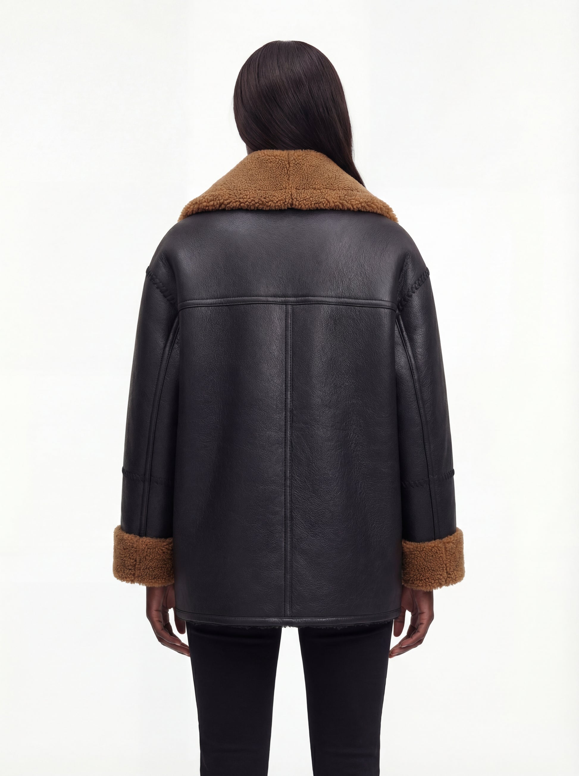 Rear view of female model wearing Maverick Noa shearling jacket showing dropped shoulders and straight back paneling. Maverick Noa.