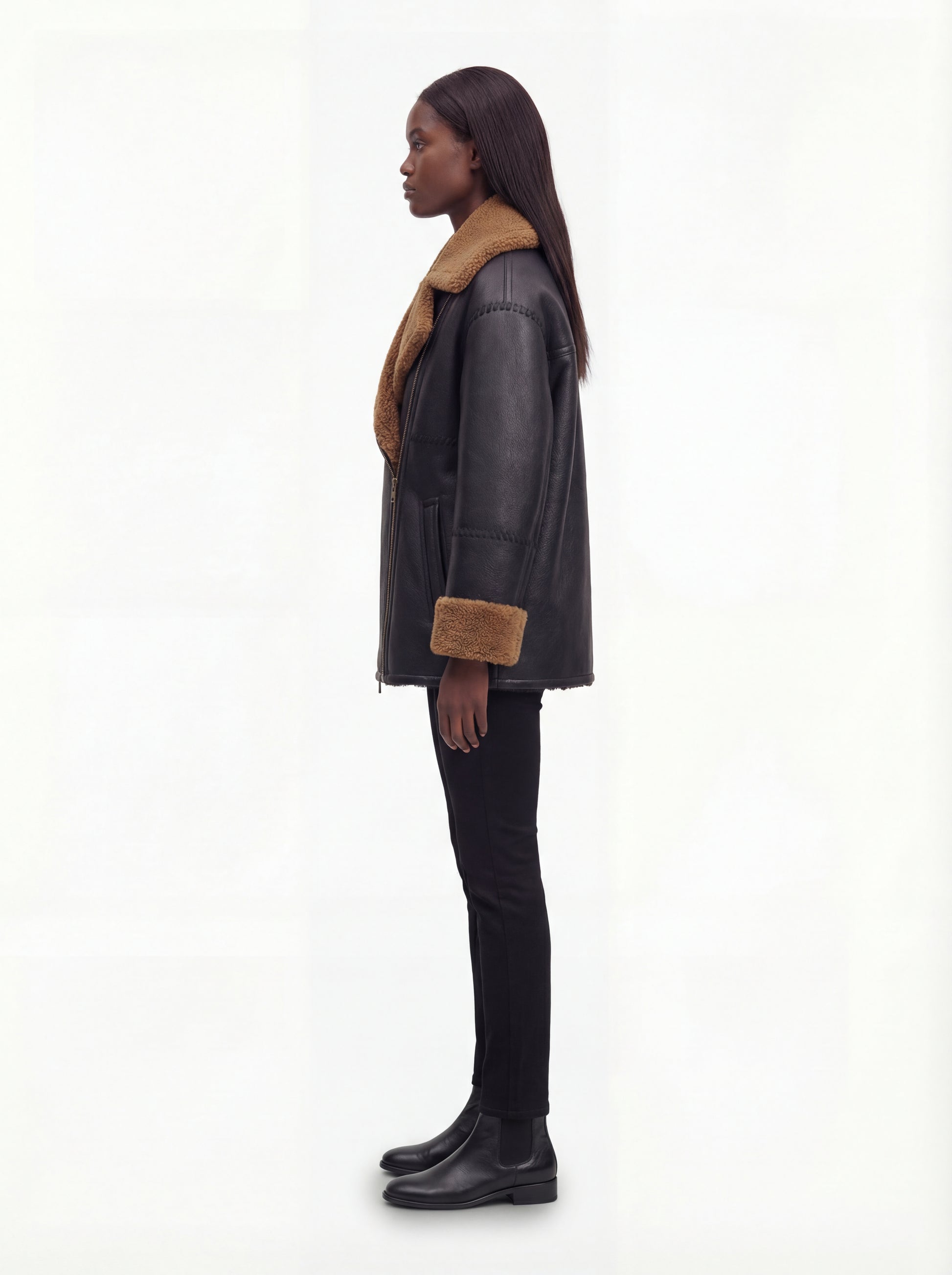 Side profile of Maverick Noa shearling jacket showing thick shearling cuffs and boxy hip-length silhouette. Maverick Noa.