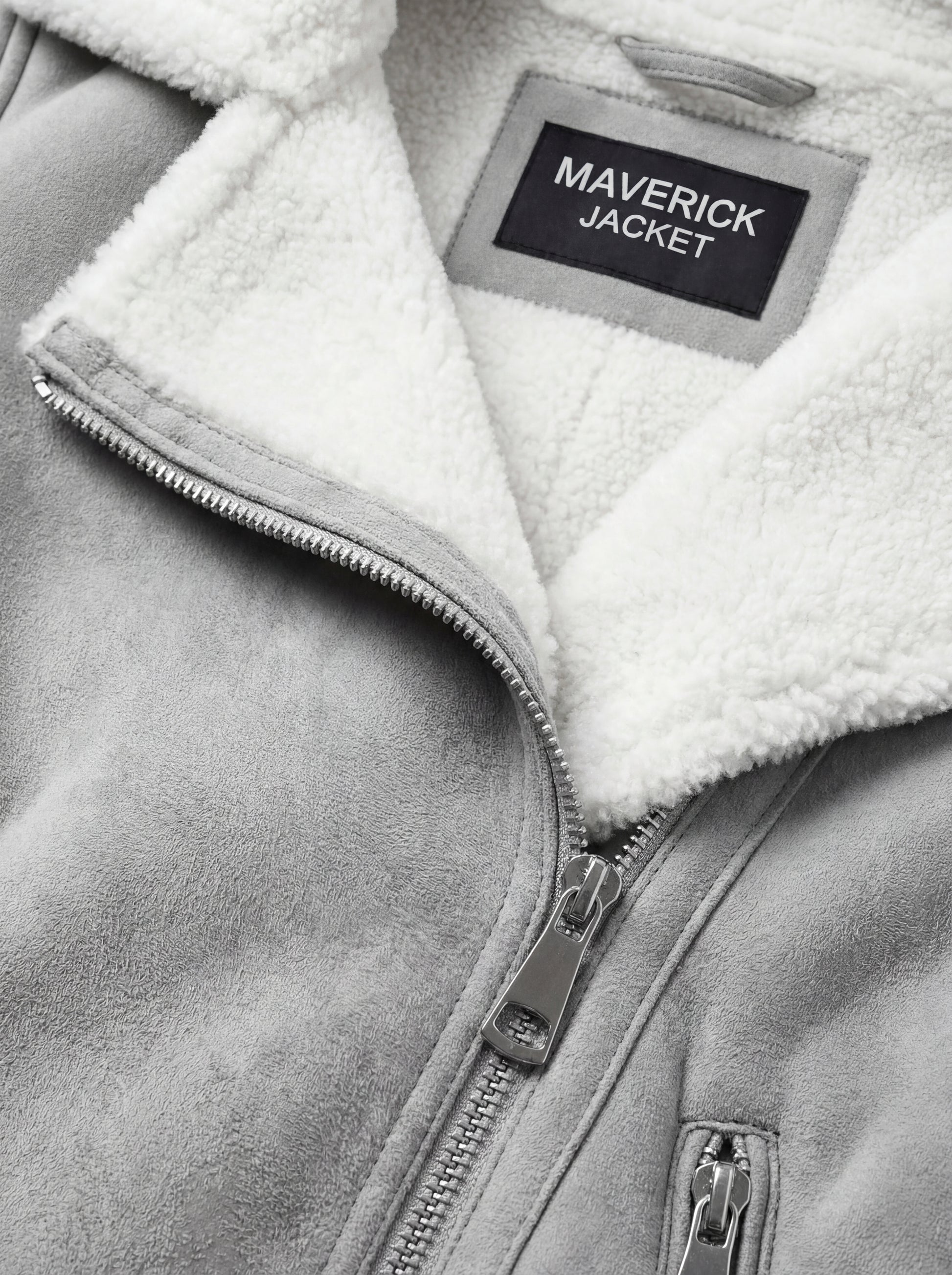 Macro shot of soft grey suede texture and silver zipper hardware on biker jacket. The Selene by Maverick Jacket.