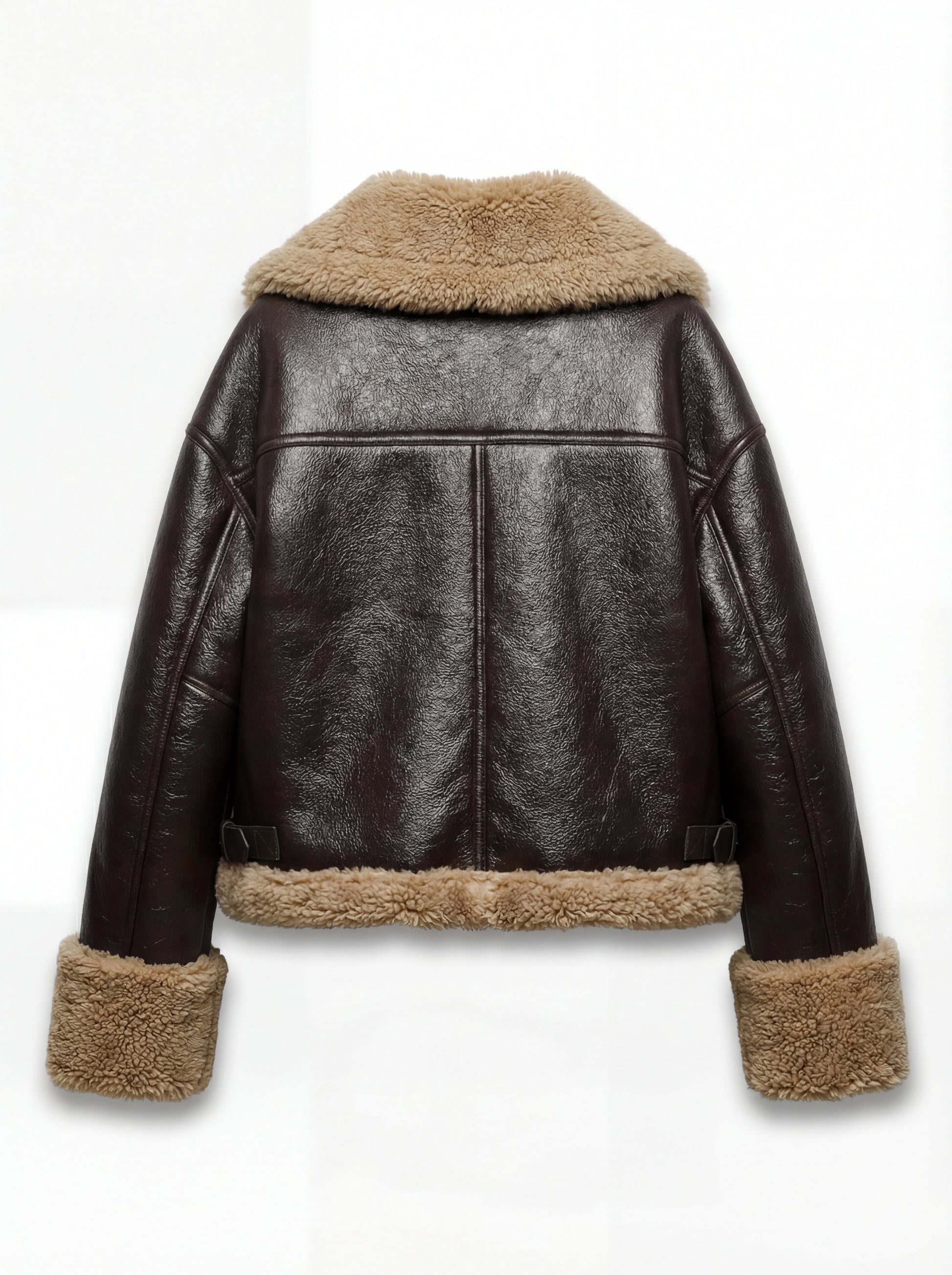 Rear view of brown leather shearling jacket showing T-shaped back yoke paneling and shearling hem. Maverick Faye.