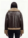 Rear view of female model wearing Maverick Faye shearling jacket showing relaxed shoulder drop and shearling-trimmed hem. Maverick Faye.