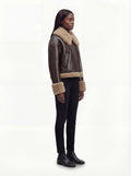 Side profile of Maverick Faye jacket showing shearling cuff detail and boxy hip-length silhouette. Maverick Faye.
