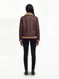 Rear view of female model wearing Maverick Sierra aviator jacket showing structured shoulders and shearling-trimmed hem. Maverick Sierra.