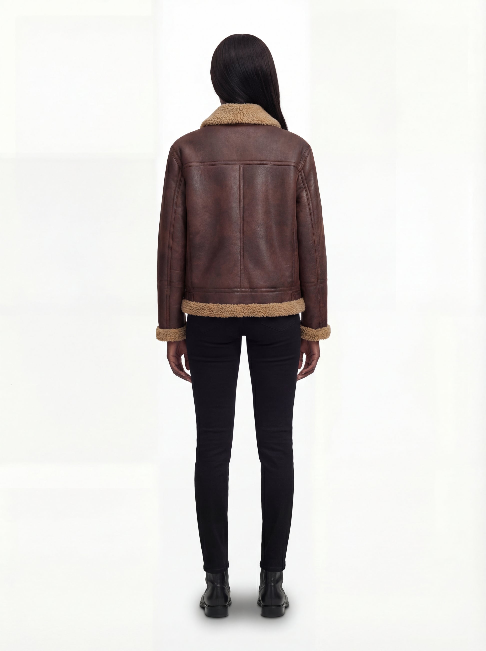 Rear view of female model wearing Maverick Sierra aviator jacket showing structured shoulders and shearling-trimmed hem. Maverick Sierra.