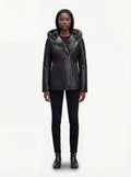 Female model wearing Maverick Genevieve hooded shearling coat, slim fit, styled over a knit sweater with skinny black jeans. Maverick Jacket.