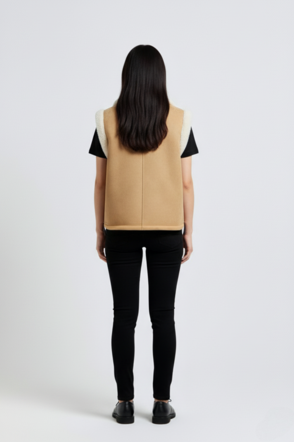 Rear view of female model wearing Maverick Elle shearling vest showing structured shoulder fit and straight back styling. Maverick Jacket.
