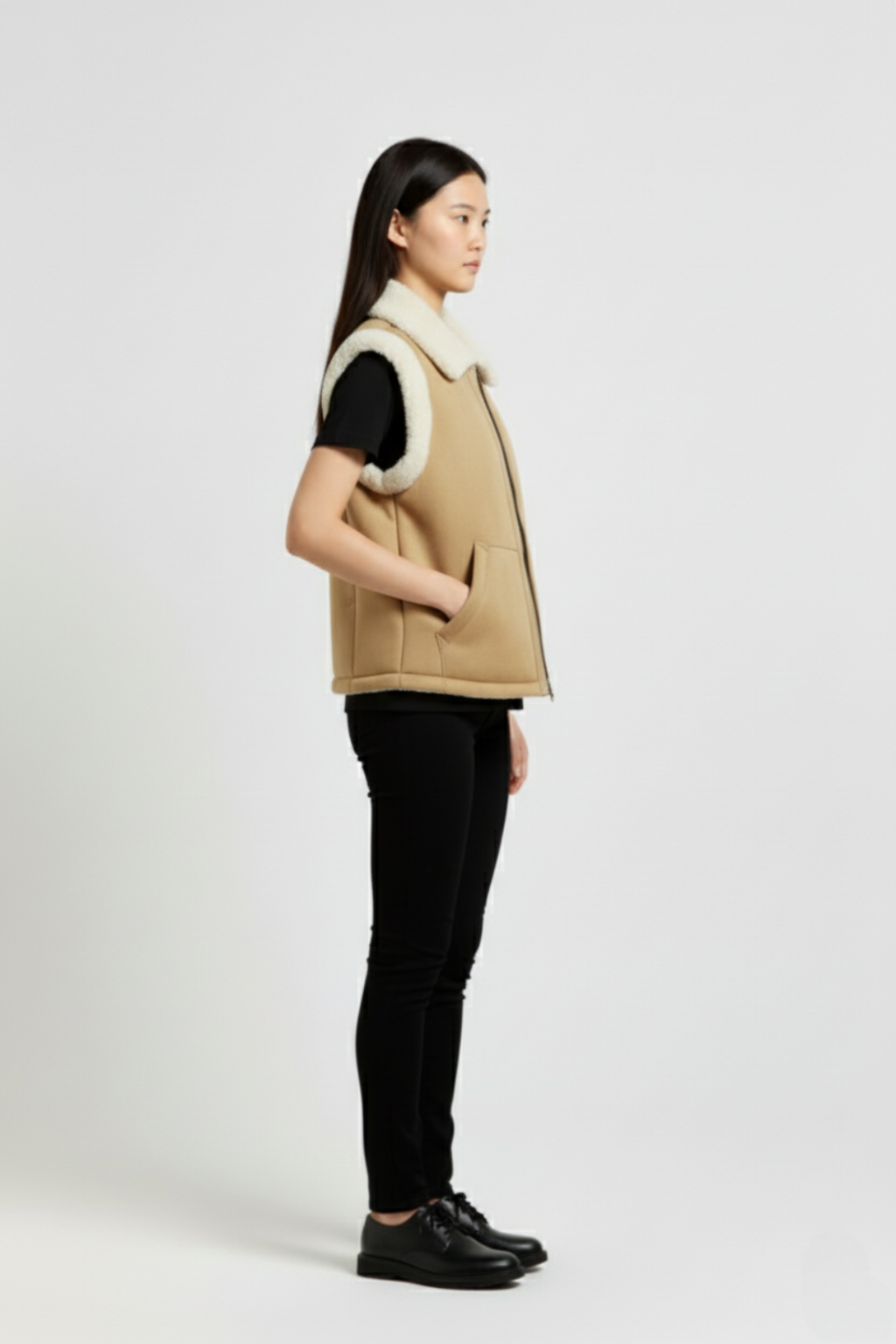 Side profile of Maverick Elle shearling vest showing shearling-trimmed armholes and boxy hip-length silhouette. Maverick Jacket.
