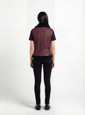 Rear view of female model wearing Maverick Valentina shearling vest showing structured shoulder fit and belted hem styling. Maverick Jacket.
