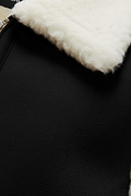 Macro shot of black nubuck texture and silver zipper hardware near cream wool collar on vest. The Elle by  Maverick Jacket.