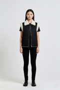 Female model wearing Maverick Elle shearling vest, relaxed fit, styled with black t-shirt and black skinny trousers. Maverick Jacket.